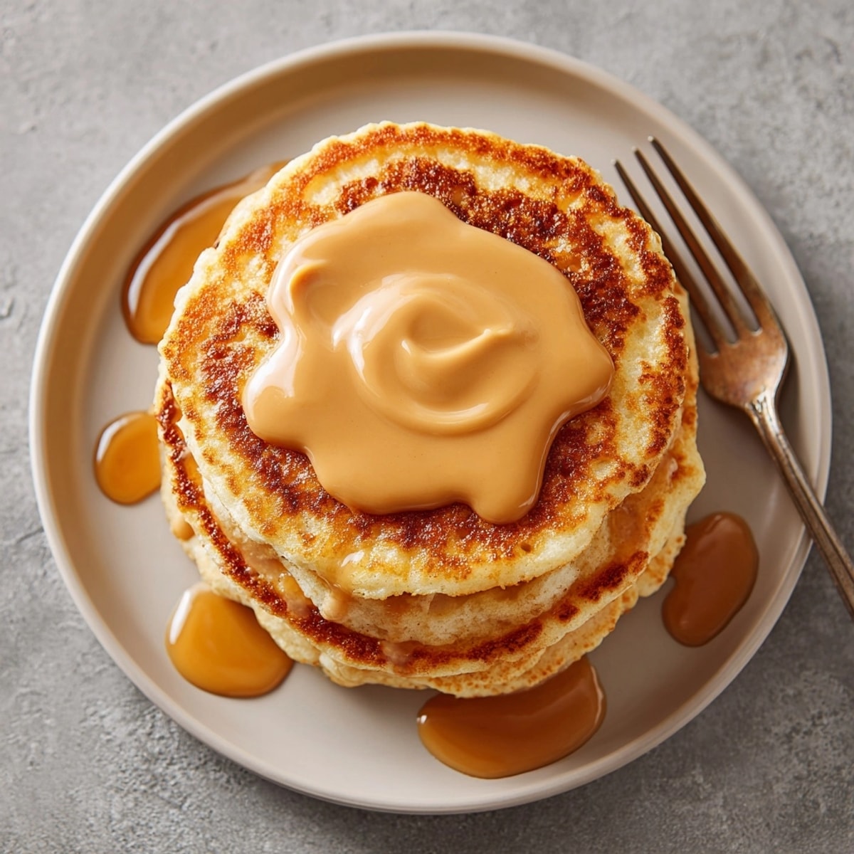 Fluffy protein pancakes served warm with rich peanut butter syrup, ideal for a satisfying brunch.
