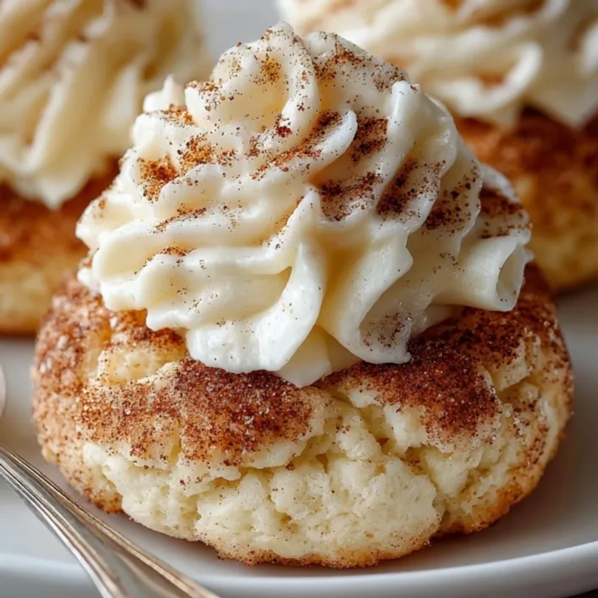 Close-up of Cinnamon Sugar Cloud Cookies with Cream Cheese Frosting, showcasing velvety icing and golden-baked edges.