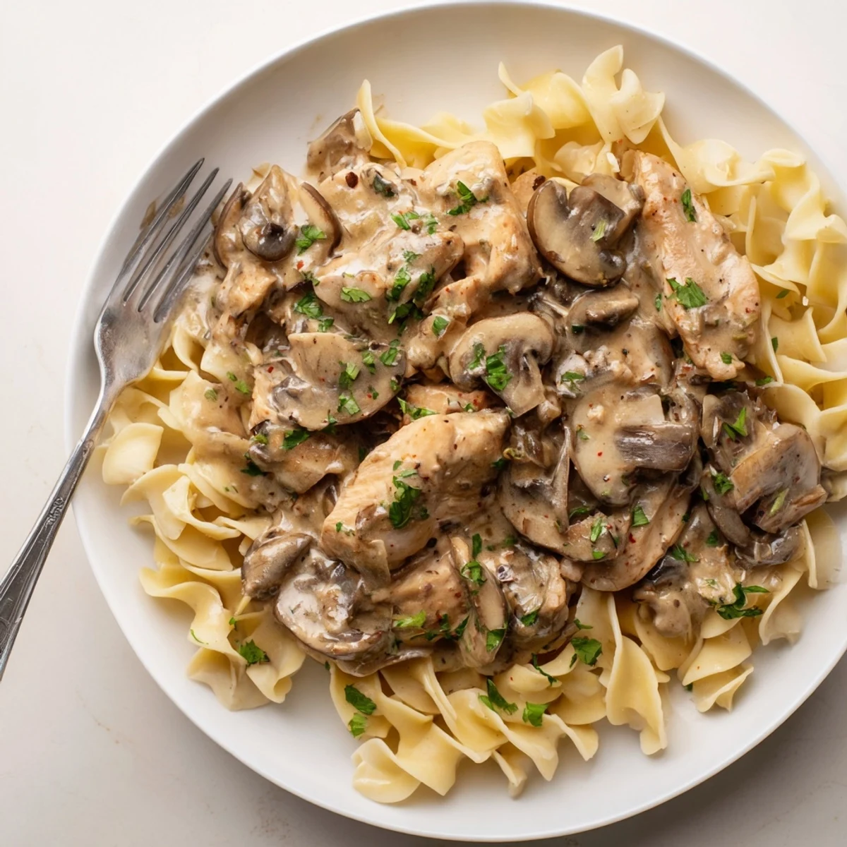 Delicious Creamy Chicken Stroganoff bubbling in a skillet, rich with mushrooms and garlic.  