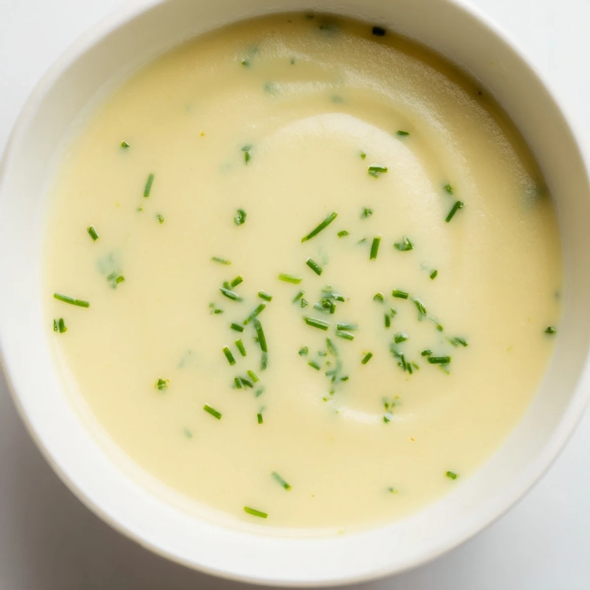 Creamy Potato Leek Soup, a comforting bowl of pureed soup, garnished with fresh chives, ready to eat.