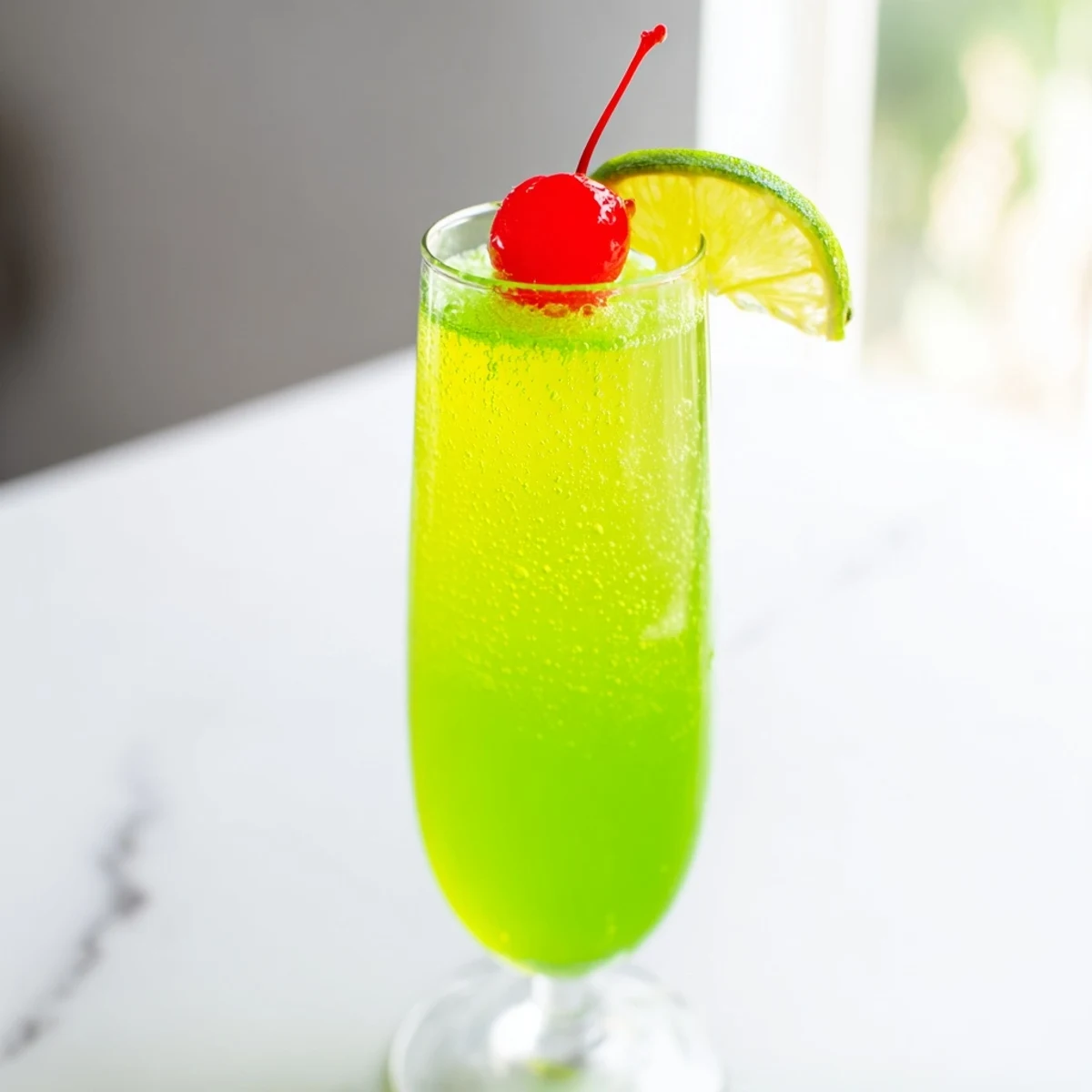Bright green Quick Grinch Mimosa Mocktails, garnished with cherries, offer a refreshing holiday sip.