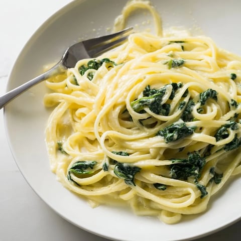 Creamy Greek Yogurt Spinach Alfredo Pasta with vibrant green spinach and grated Parmesan, ready to enjoy.