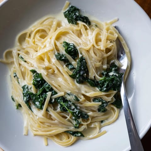 A close-up shot of Creamy Greek Yogurt Spinach Alfredo Pasta, a comforting vegetarian meal perfect for dinner.