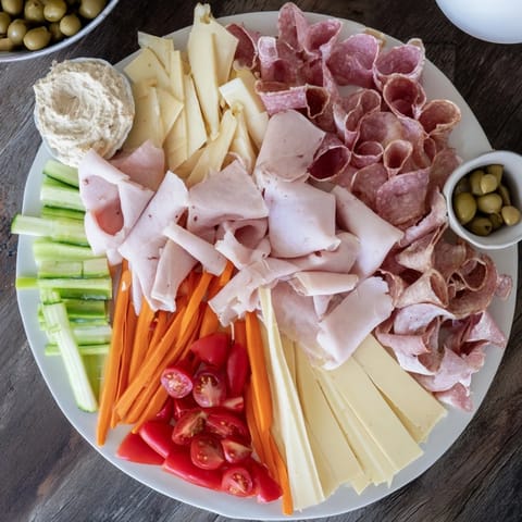 A beautifully arranged Budget-Friendly Family Spread with hummus and olives ready to delight guests.