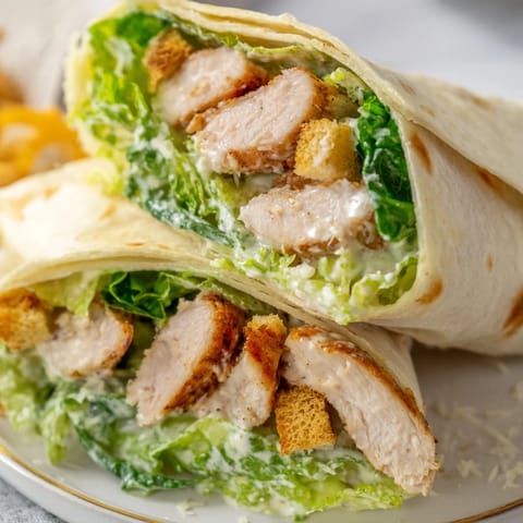 Fresh Caesar Chicken Salad Wrap with crisp croutons and grated parmesan, perfect for a handheld lunch.