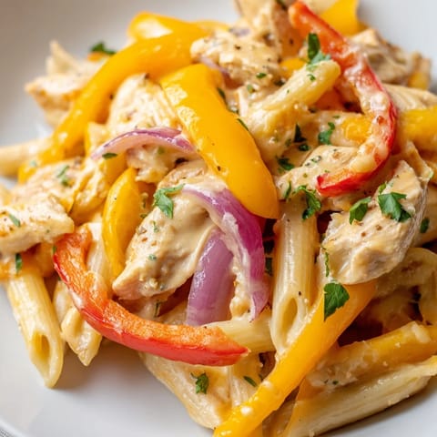 Sizzling, creamy Fajita Chicken Pasta Skillet with vibrant peppers, onions, and melted cheese.