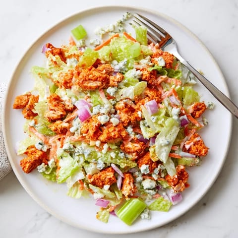 A hearty Buffalo Chicken Chopped Salad garnished with cherry tomatoes and drizzled with ranch dressing.