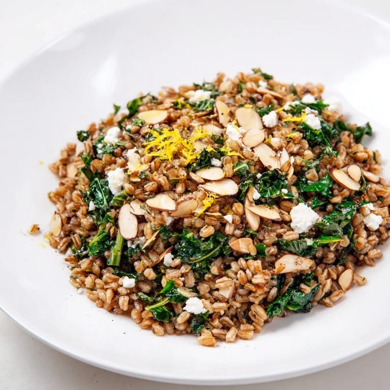 A vibrant bowl of warm farro & greens pilaf; the aroma of lemon and herbs is inviting.
