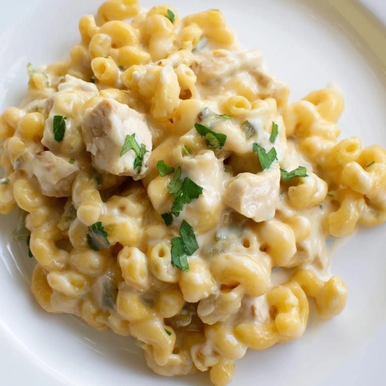 Close-up of Green Chili Chicken Mac with shredded chicken, sharp cheddar, and mild diced green chiles in a velvety, cheesy sauce.